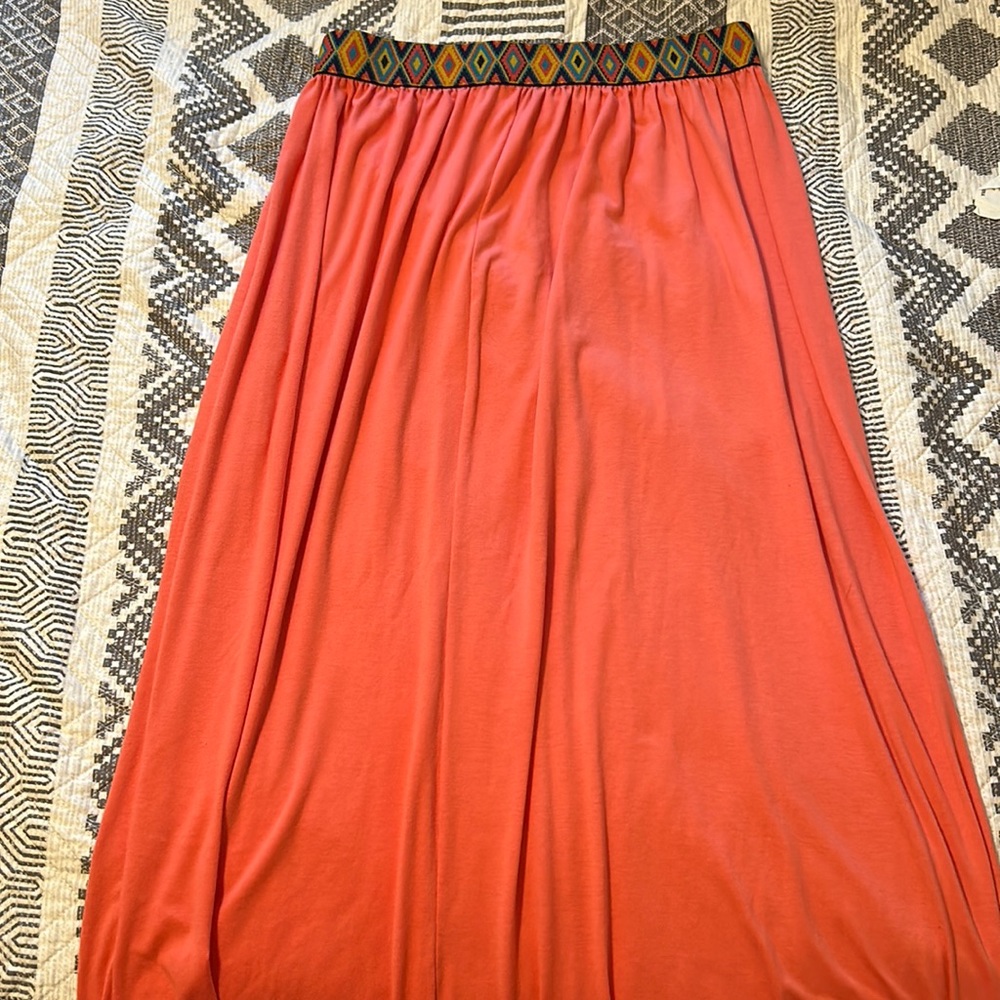 Long coral colored skirt with multi-colored waist band